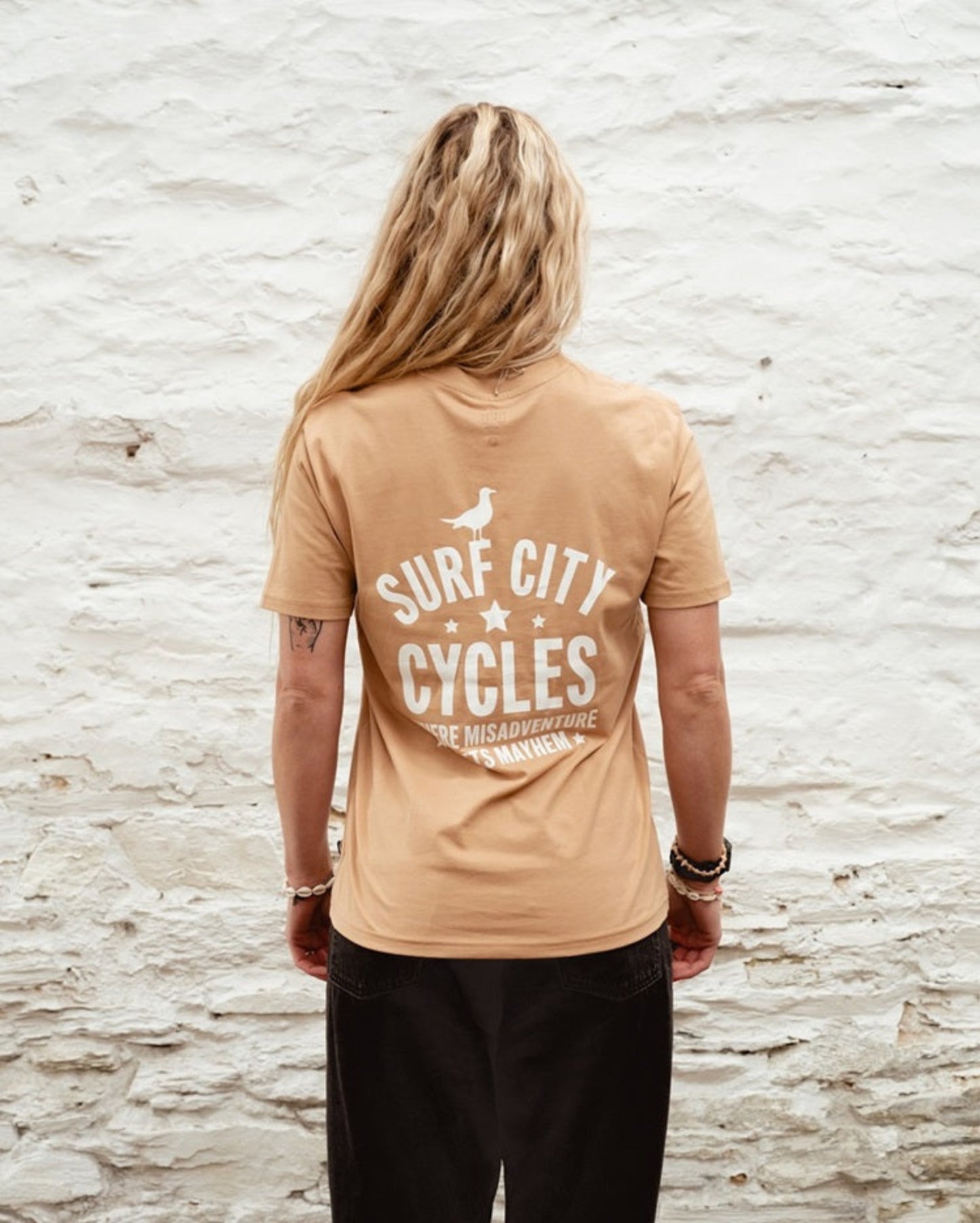 Latte Surf City Cycles Misadventure T-shirt back view worn by female model