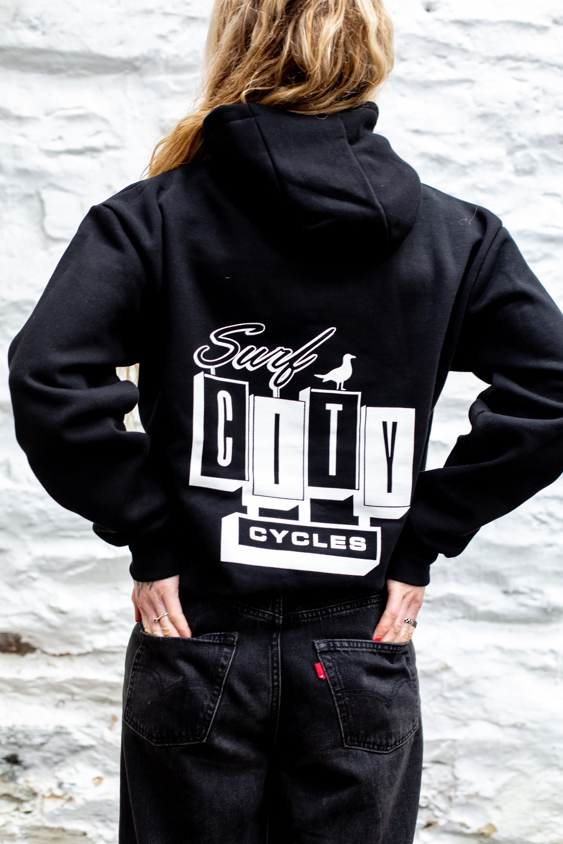 Black hoodie by Surf City Cycles, close-up of hood and drawstring, cotton fleece