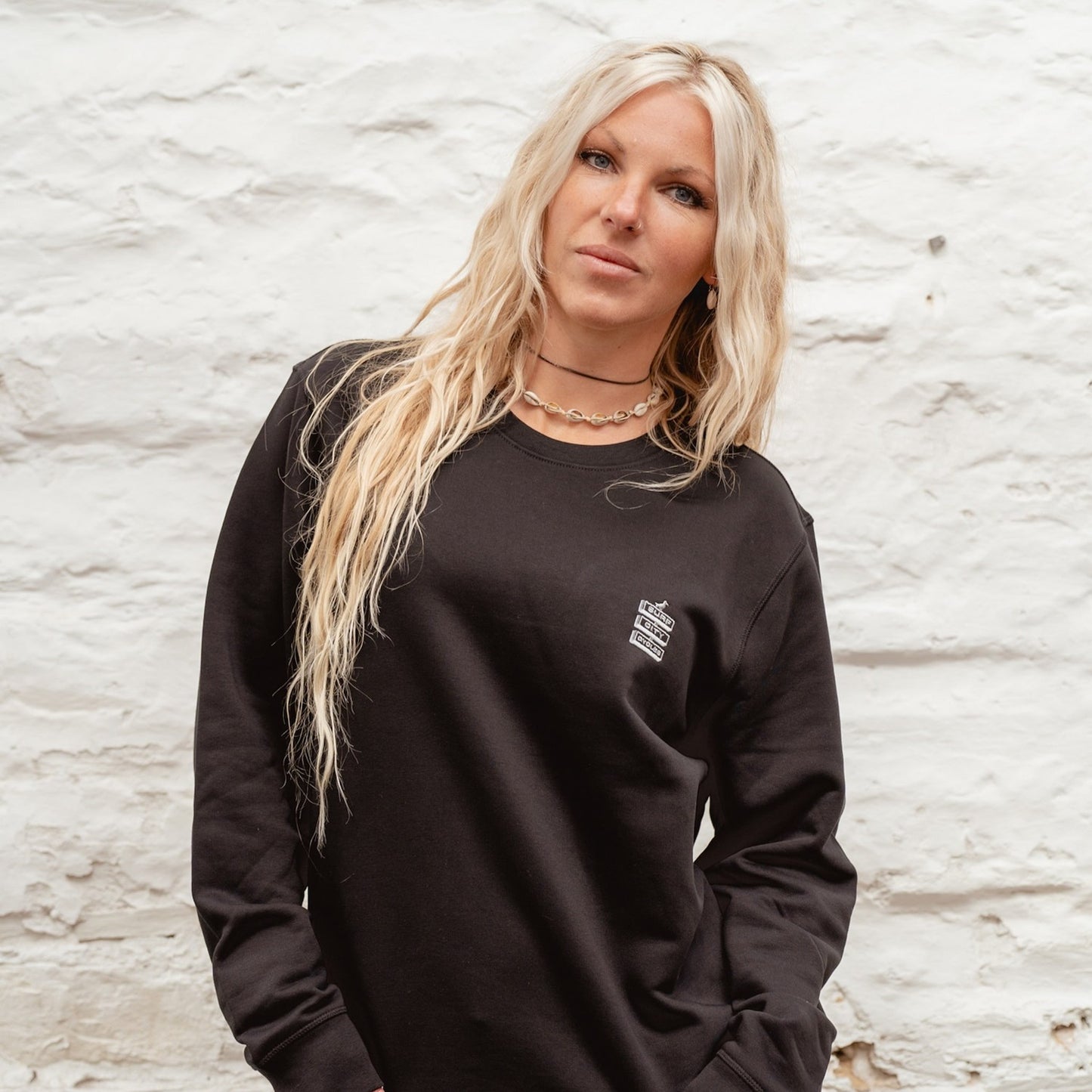 Female model in a classic black Boulevard crewneck sweatshirt, showcasing the relaxed fit and minimalist chest branding.