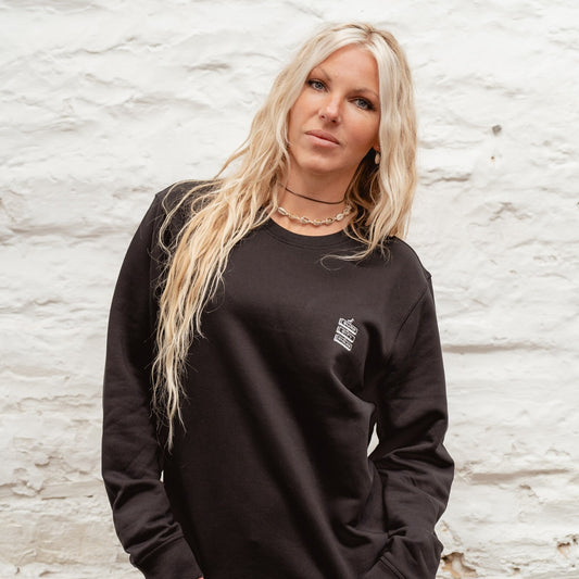 Female model in a classic black Boulevard crewneck sweatshirt, showcasing the relaxed fit and minimalist chest branding.