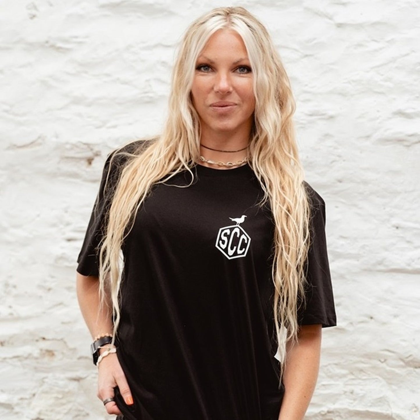 Female model wearing the black "Misadventure" crewneck with white motorcycle graphic.