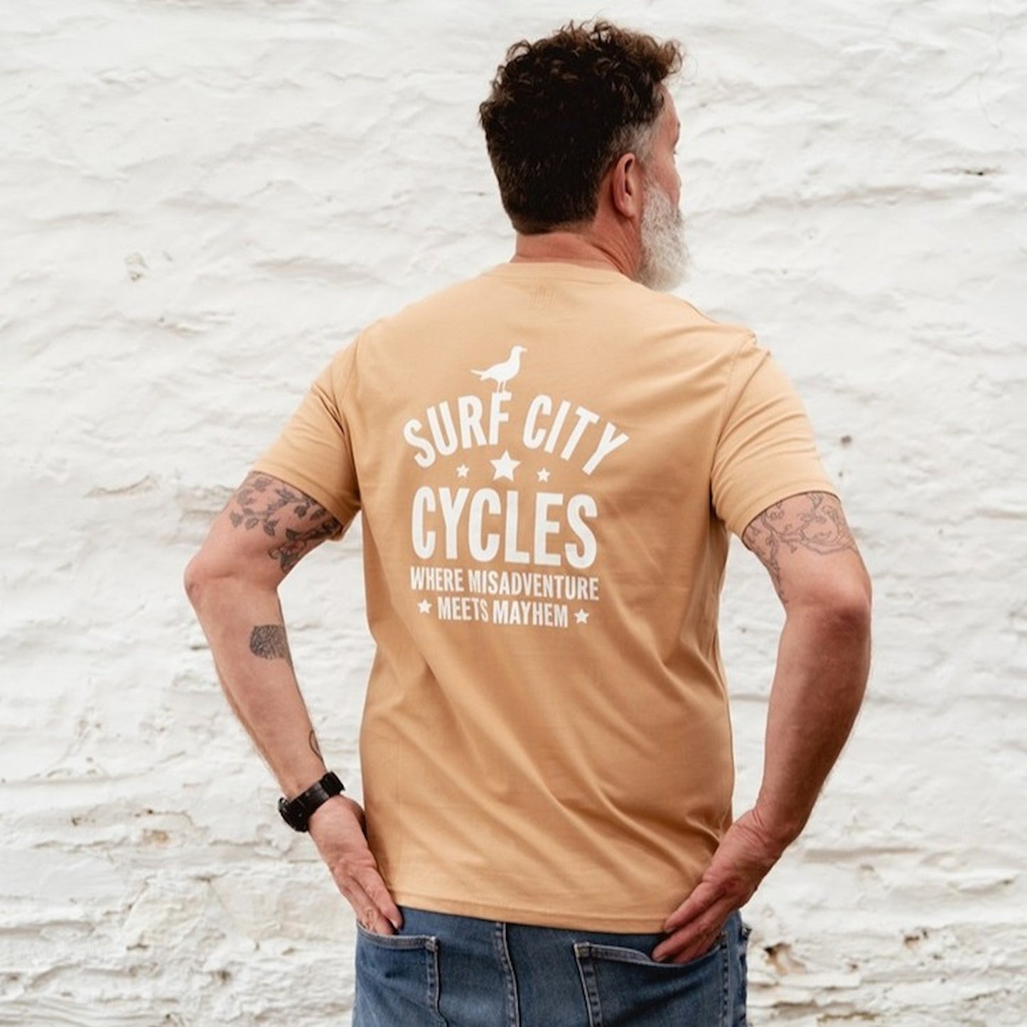 Close-up of the "Misadventure" chest graphic featuring a skeleton on a motorcycle on a latte-coloured cotton tee.