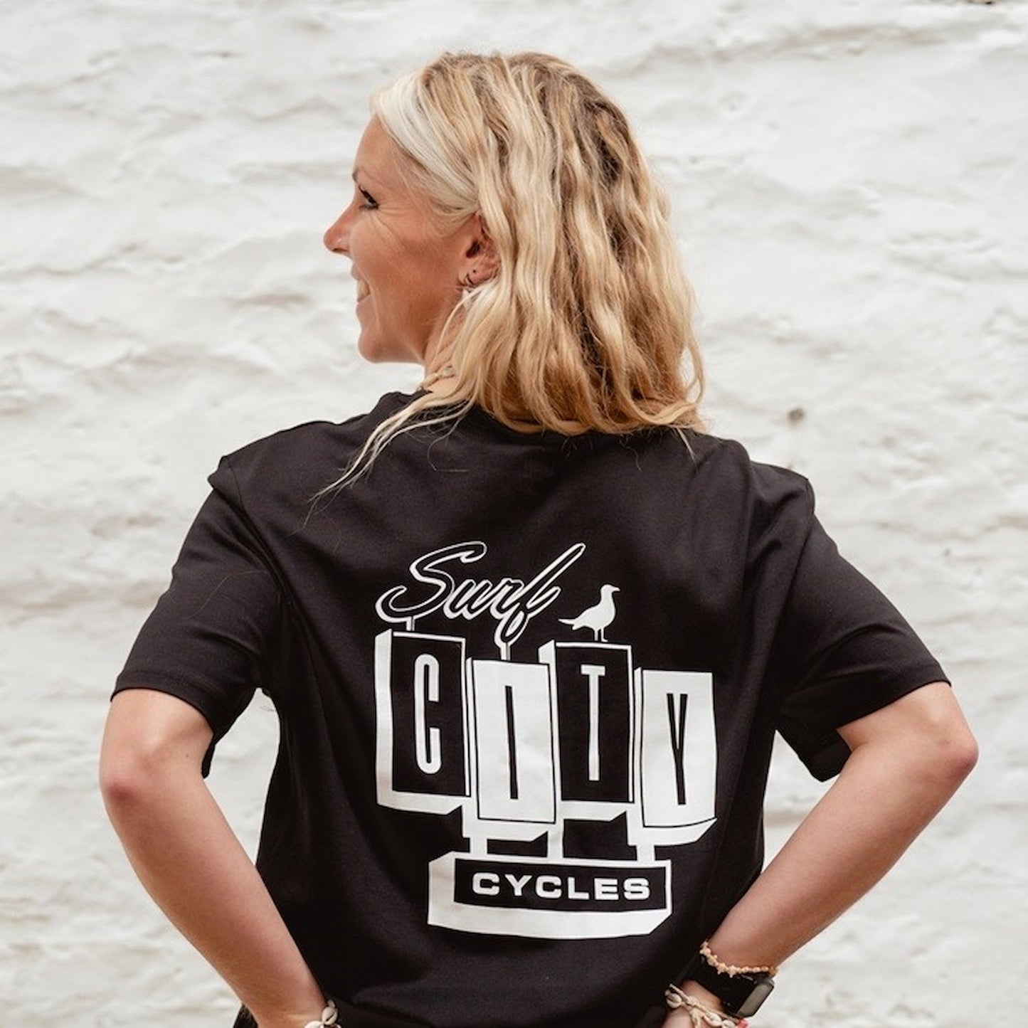 Back view of the Black OG Logo organic cotton tee, featuring the large high-contrast Surf City Cycles block logo and bird graphic