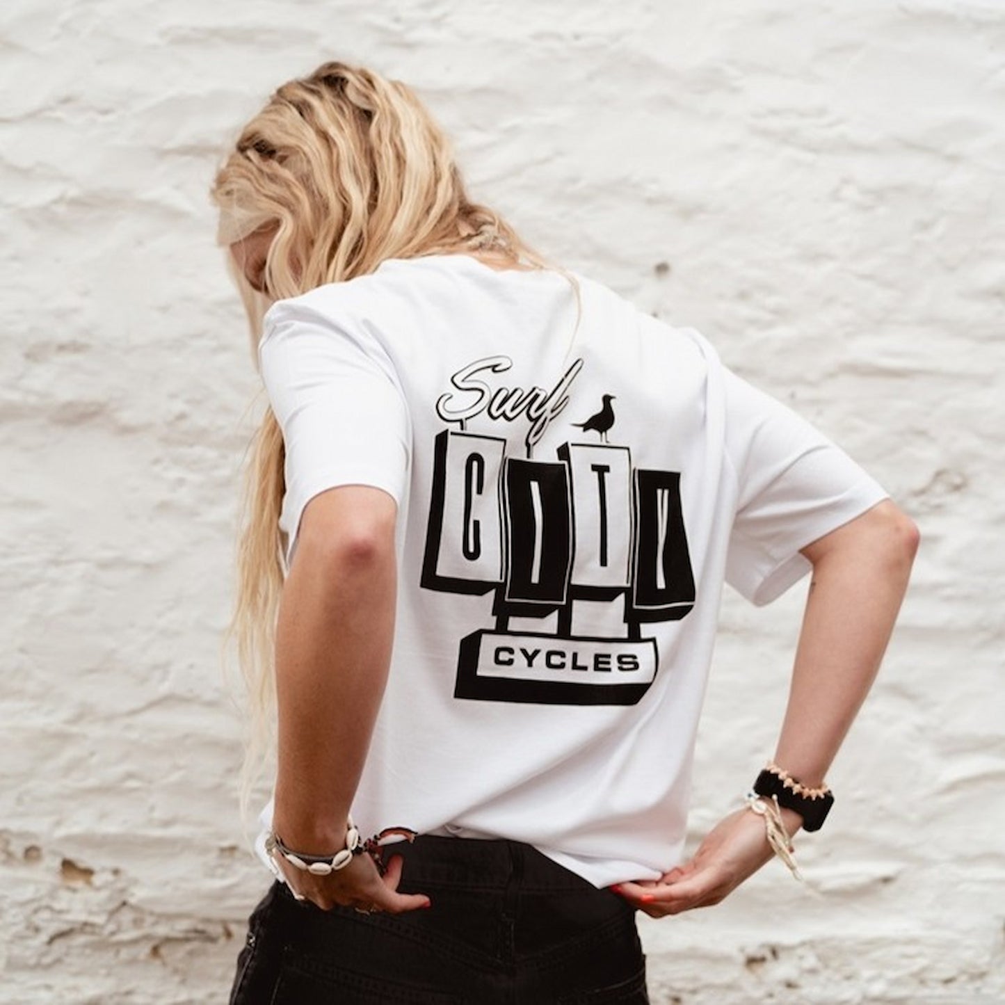 Back view of the White OG Logo organic cotton tee, featuring the large Surf City Cycles block logo and bird graphic.
