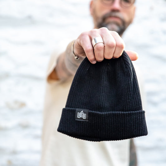 The Seafarer Organic Ribbed Beanie in Black, featuring the Surf City Cycles SCC woven clip label.
