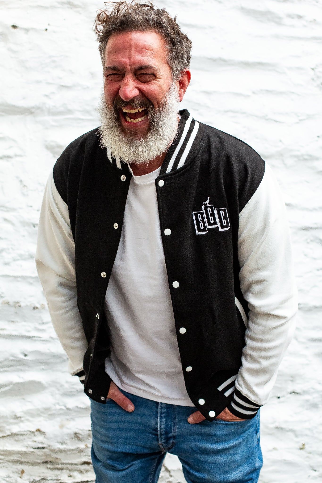 Black and cream varsity jacket by Surf City Cycles worn outdoors, lifestyle shot, unisex