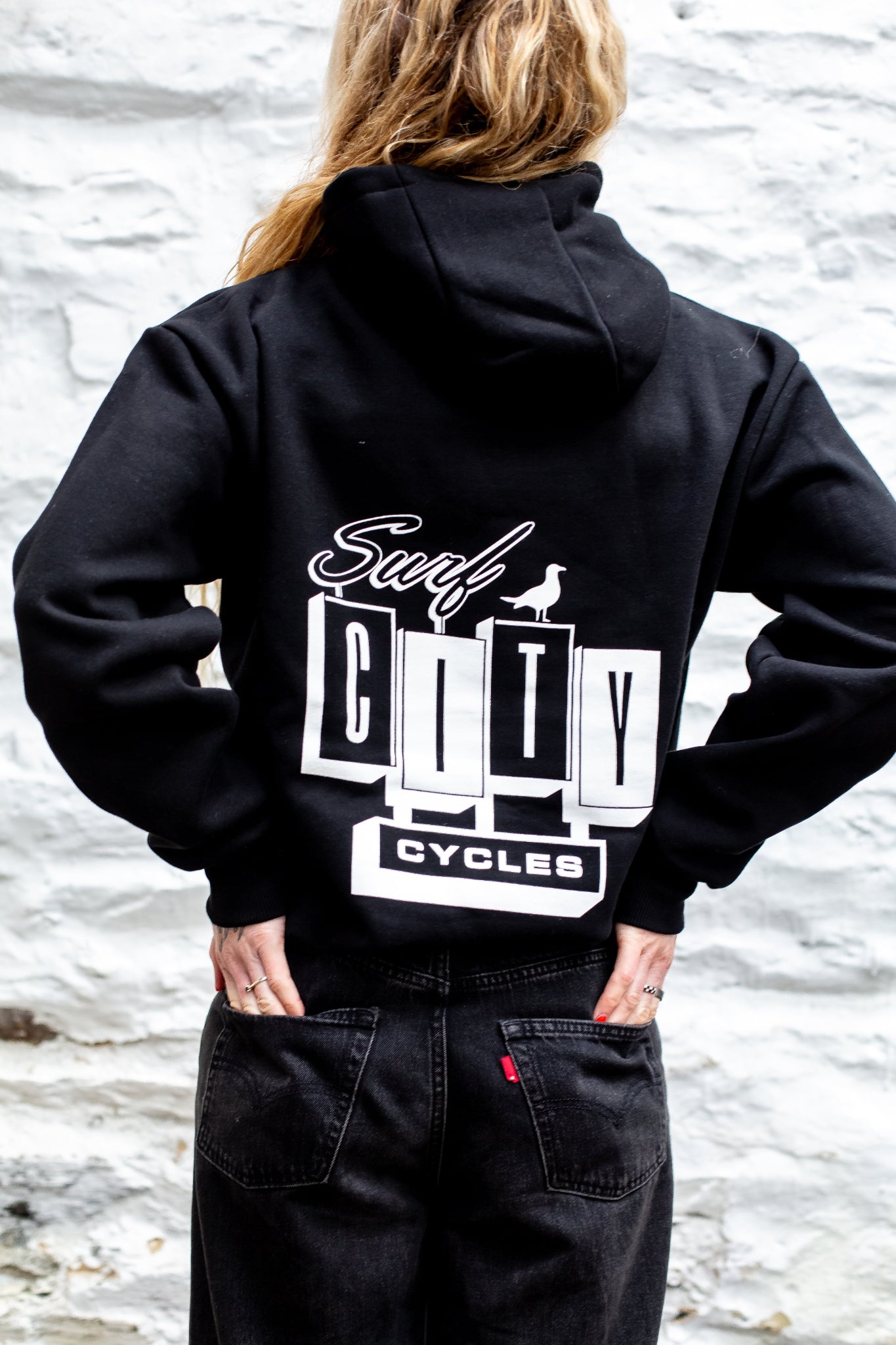 Black pullover hoodie by Surf City Cycles, close-up of fabric and stitching