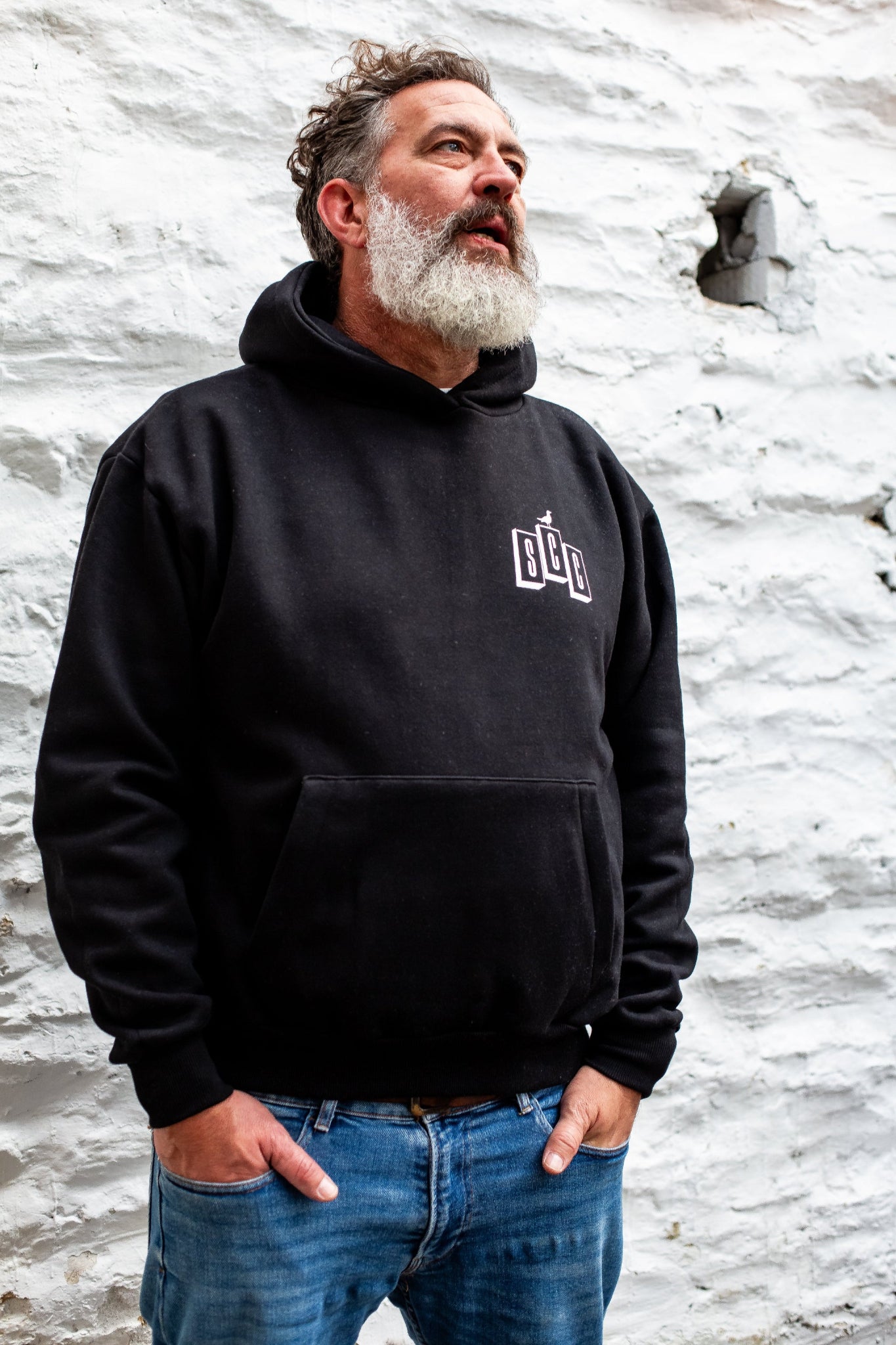 Black pullover hoodie by Surf City Cycles worn casually, surf-moto inspired clothing