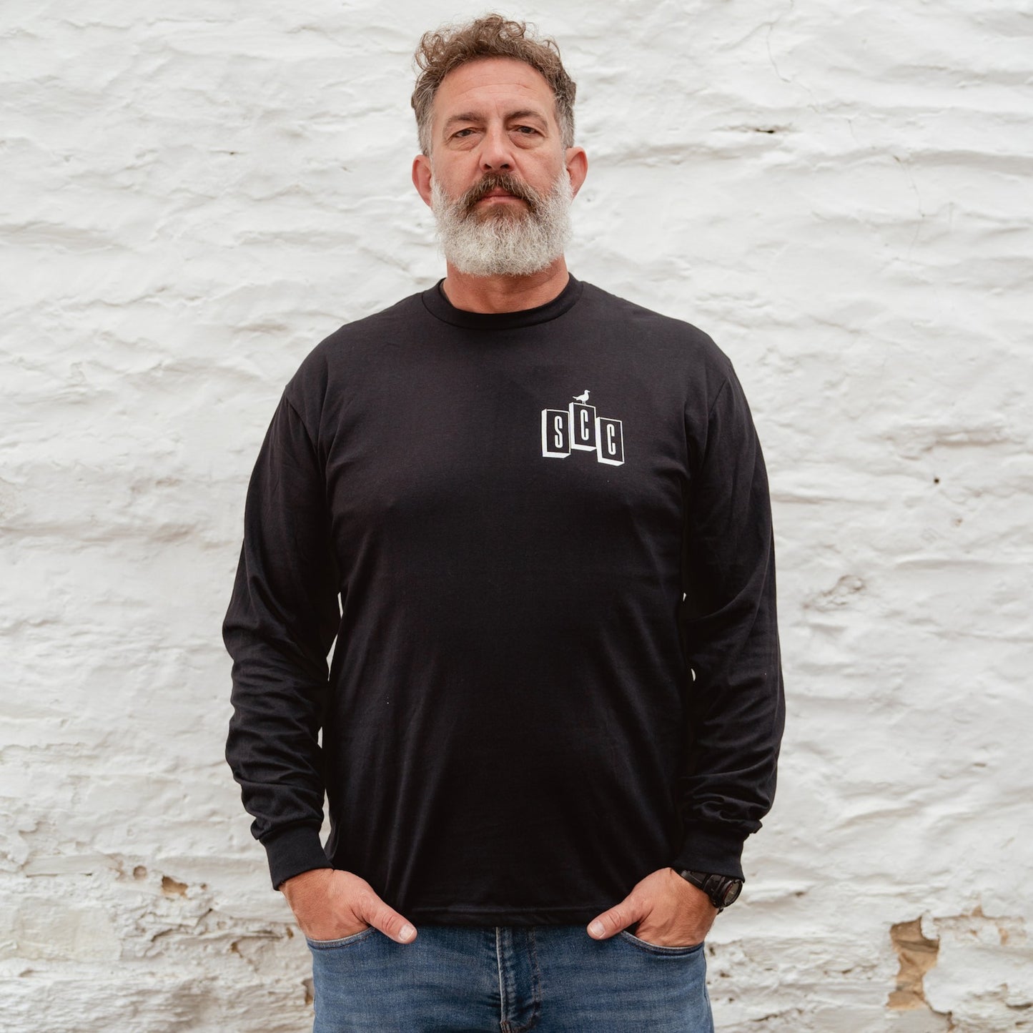 Candid lifestyle shot in Project 83 Newquay featuring the Surf City Cycles black long sleeve OG logo tee.