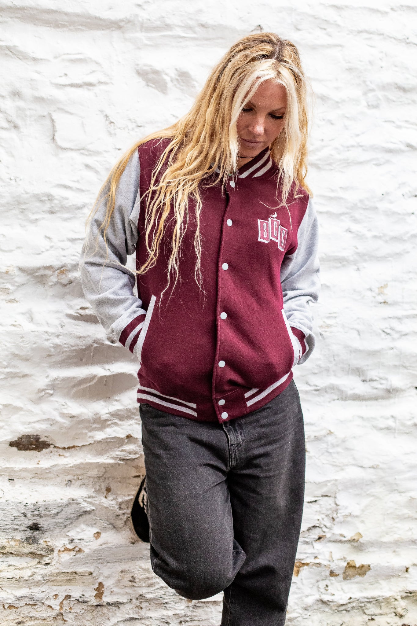 Burgundy and heather varsity jacket by Surf City Cycles worn outdoors, lifestyle shot, unisex