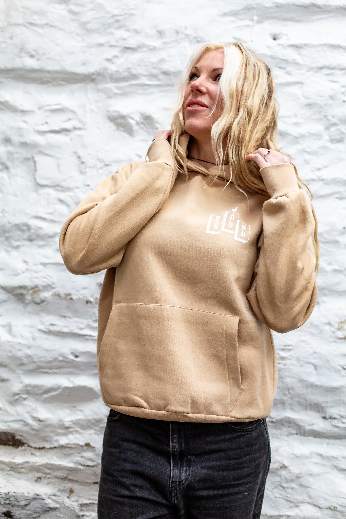 Black pullover hoodie by Surf City Cycles worn casually, surf-moto inspired clothing