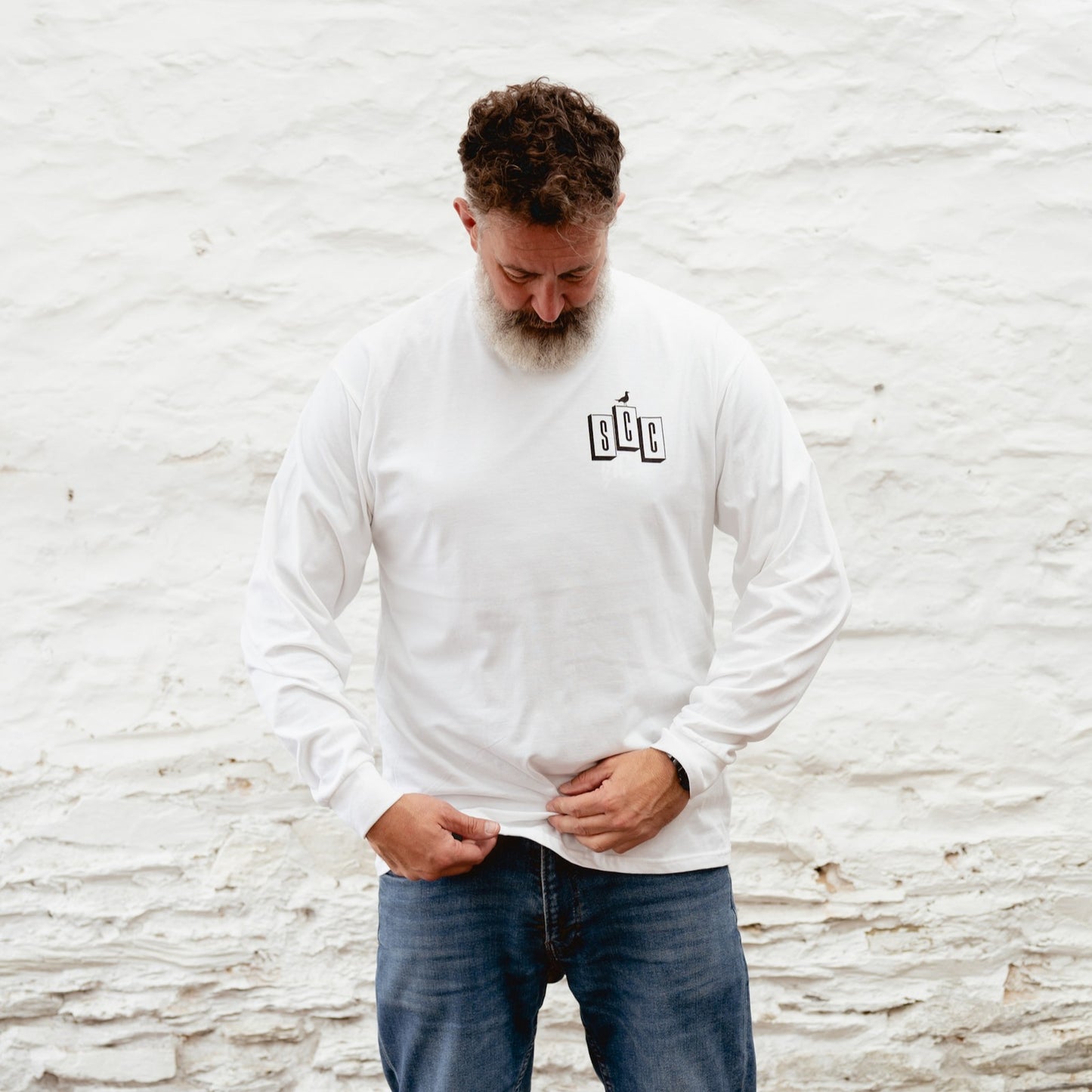 Andrew Pringle wearing the white Surf City Cycles OG logo long sleeve shirt in Project 83.