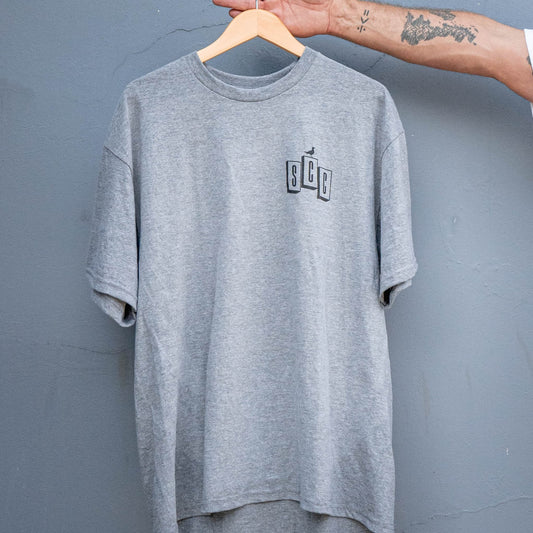 Front view of the heather grey signature logo t-shirt, showing the small vertical SCC chest graphic.
