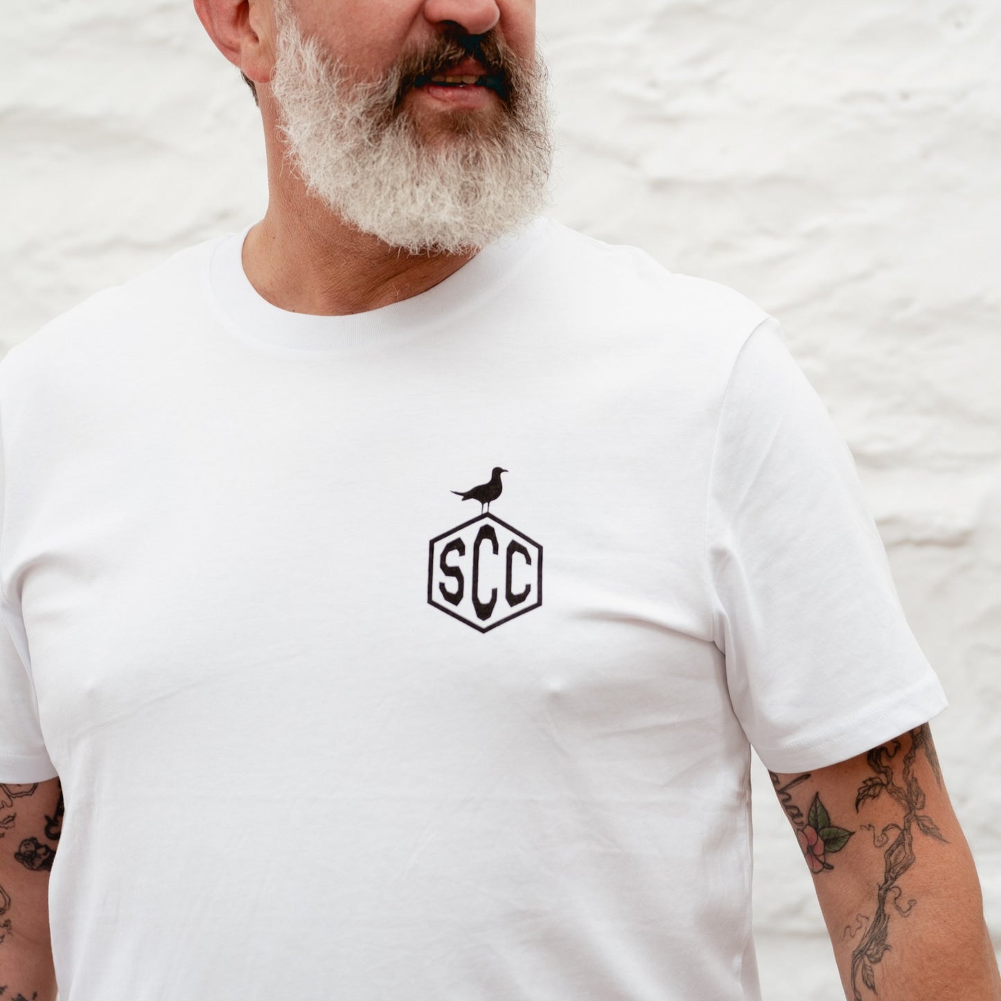 Candid lifestyle shot of a man in the Surf City Cycles workshop, capturing the authentic moto-culture vibe.