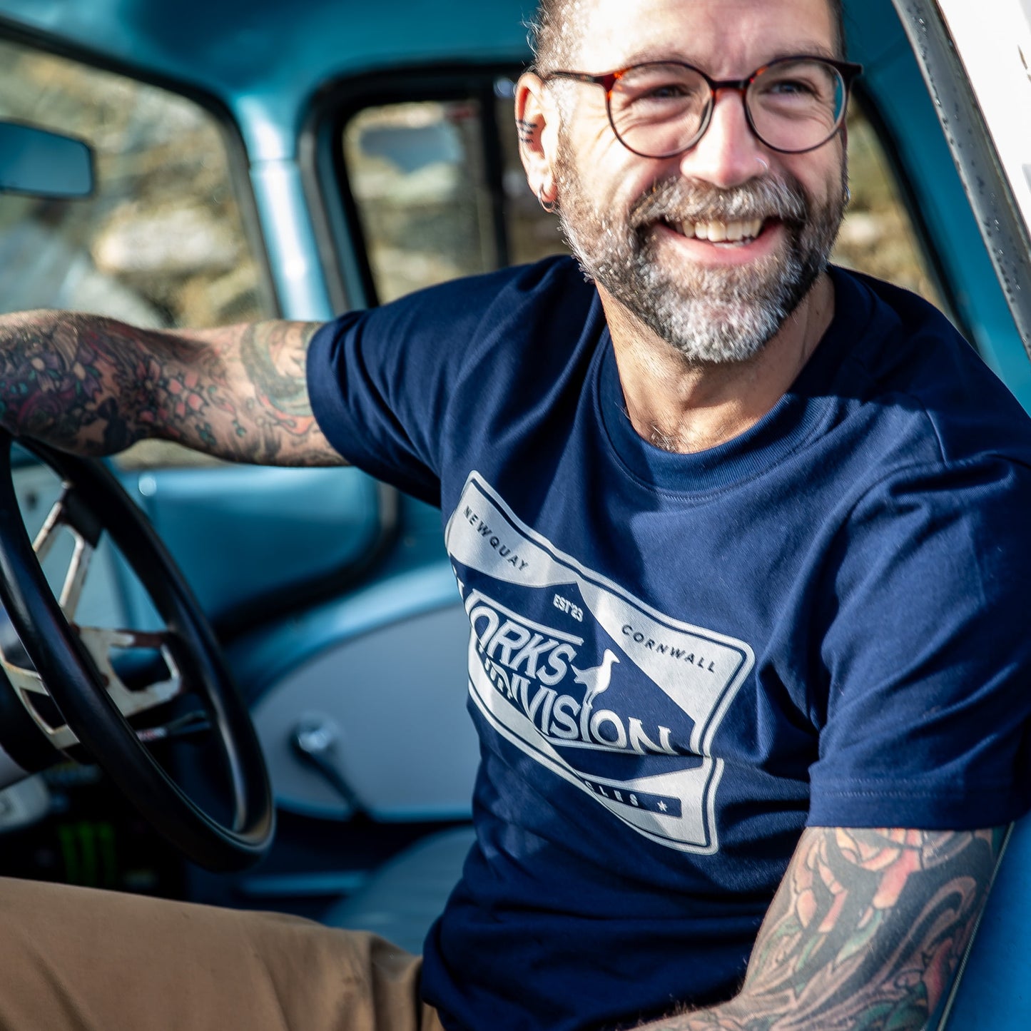 lifestyle shot of the Navy Works Division Heavy Utility Tee worn while driving a classic truck, highlighting the relaxed fit.